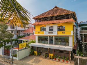 科钦The Hosteller Fort Kochi, Ocean Edge的黄色建筑,有红色屋顶
