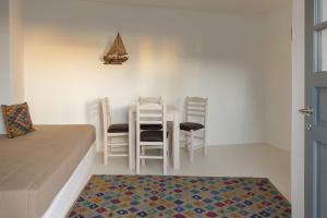 a room with a table and chairs and a bed at Rustic Stone House in the Heart of Folegandros in Áno Meriá