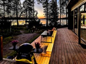 un ponte con panchine e un tavolo su una casa di Niemi-Kapee Sammal - modern cottage by the lake Näsijärvi a Tampere