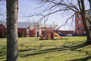 a playground with a slide in a yard with a building at Rahukodu in Kõrgessaare