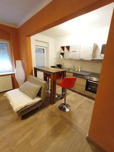 a kitchen with a table and a red stool in a room at kleine 1-Raum-Ferienwohnung mit hohem Komfort in Teuchern