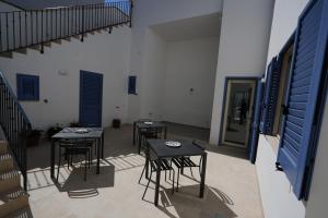 four tables and chairs in a room with blue doors at Vista Mare Rooms in Porto Cesareo +19 photos
