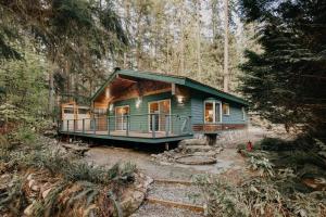 a house in the middle of a forest at Glacier Springs Cabin 60 - Soaker Tub - Blu-Ray - Sleeps 4 in Maple Falls