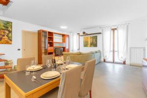 une salle à manger et un salon avec une table et des chaises dans l'établissement Residenza degli Ulivi, Green House with Pool at Sassabanek, à Iseo 20 autres photos