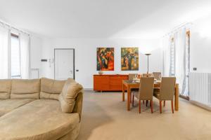 un salon avec un canapé et une table avec des chaises dans l'établissement Residenza degli Ulivi, Green House with Pool at Sassabanek, à Iseo
