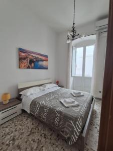 a bedroom with a bed and a chandelier at Casa Aurora in Polignano a Mare +14 photos