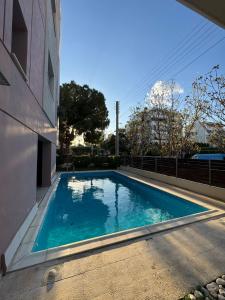 a swimming pool on the side of a building at Cosy apartment with shared pool and garden in Athens