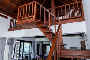 a wooden spiral staircase in a living room at Baan Fah Sai in Koh Phangan