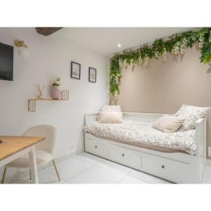 a room with a bed with plants on the wall at Centre ville - Proche Théatre - Martelly in Grasse