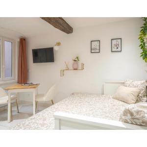 a white bedroom with a bed and a desk at Centre ville - Proche Théatre - Martelly in Grasse
