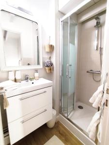 un bagno bianco con doccia e lavandino di Chambre du Rouard LE RUISSEAU a Camiers
