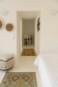 a bedroom with a bed and a dining room at Rustic Stone House in the Heart of Folegandros in Áno Meriá