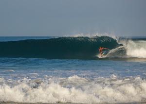 a person riding a wave on top of a surfboard at Hotel Rip Jack Inn in Playa Grande
