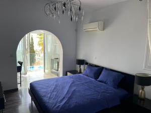 Un dormitorio con una cama con un edredón azul. en Villa Daria Kamares Tala Luxury Sea View, en Pafos 60 fotos más