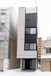 a black and white building next to some buildings at 3 room in the center of Sapporo in the walking area of Odori Park toilet x 2 bathroom x 1 parking Shimizu model in Sapporo