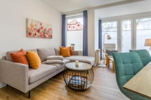 a living room with a couch and a table at Sünnslag 103 - "Ferienhaus Ostseezauber" - 4 Zimmer, im Herzen Boltenhagens in Boltenhagen