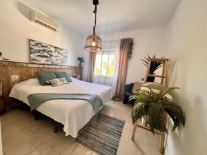 a bedroom with a bed and a plant in it at Casa Ibicenca - Precioso chalet con piscina in Peñíscola +32 photos