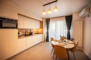 a kitchen and dining room with a table and chairs at Erato Apartment in Odyssey Spa Pool & Fitness Resort-parking in Mamaia