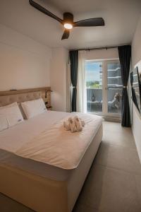 a bedroom with a bed with two towels on it at Erato Apartment in Odyssey Spa Pool & Fitness Resort-parking in Mamaia