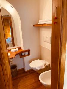 a bathroom with a toilet and a sink and a mirror at B&B Pichler Casa in Castello di Fiemme
