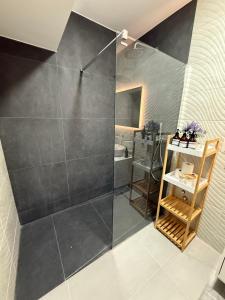 a bathroom with a shower with a glass door at Evo apartments VRT No 1 in Şelimbăr