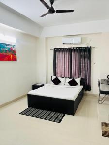 a bedroom with a bed and a ceiling fan at Alpine Inn in Guwahati