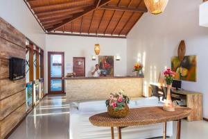 a living room with a table and a counter at Enseada dos Corais Praia Hotel in Arraial d'Ajuda