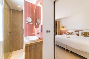 a bedroom with a bed and a sink and a shower at Les Capucines Saint Tropez in Saint-Tropez