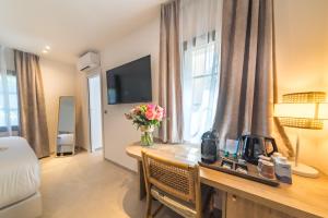 a hotel room with a desk with flowers on it at Les Capucines Saint Tropez in Saint-Tropez