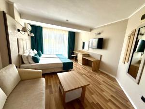 a hotel room with a bed and a couch at Hotel Rеgina - Golden Sands All Inclusive in Golden Sands