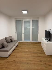 a living room with a couch and a flat screen tv at AA Apartman - Balatonboglár in Balatonboglár +7 photos
