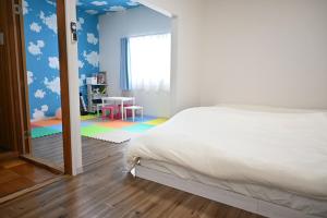 Un dormitorio con una cama y una mesa y una ventana. en Ko's HOUSE Shinmori7, en Osaka