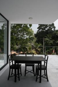 a black table and two chairs in front of a window at Kadurupokuna villa Tangalle in Tangalle