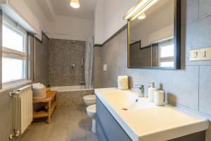 een badkamer met een wastafel, een toilet en een spiegel bij Gemelli Apartment in Rome +34 foto's