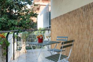 een tafel met een glas wijn en 2 stoelen op een balkon bij Gemelli Apartment in Rome
