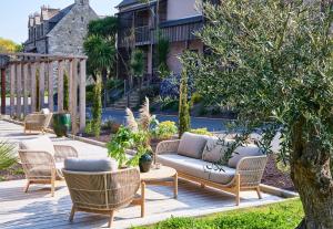 a patio with chairs and a couch on a deck at Hôtel Oré, Saint-Malo in Saint Malo