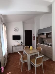 a living room with a table and chairs and a television at Raggio di Sole in Campofelice di Roccella