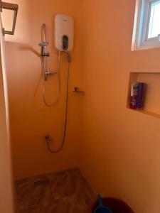 a bathroom with a shower in the corner of a room at Marinas private beach resort in Tangalan