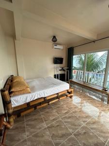 a bedroom with a bed and a large window at Marinas private beach resort in Tangalan