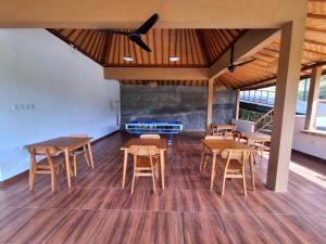 a room with wooden tables and chairs and a fireplace at Batu Jaran Hill Cottage Uluwatu in Uluwatu