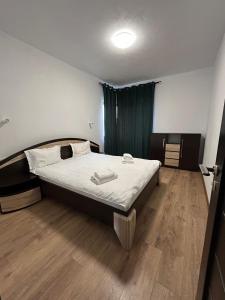 a bedroom with a large bed with a wooden floor at Dacia Apartments in Sebeş