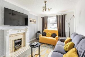 a living room with a couch and a fireplace at 3 Bed House - Sleeps 5 - Parking - Garden - Wifi in Blackburn