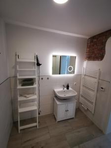 a white bathroom with a sink and a mirror at LandRäume barrierefrei in Lunden +26 photos