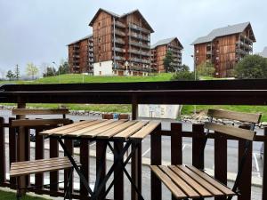 zwei Bänke auf einer Brücke mit Gebäuden im Hintergrund in der Unterkunft Studio moderne au pied des pistes, emplacement idéal, central et calme in Le Dévoluy
