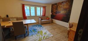 a living room with a dining room table and a painting at Ferienwohnungen 3 Birken in Briesen