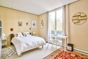 a bedroom with a bed and a desk and a window at KDL - grande maison proche de Paris in Boulogne-Billancourt