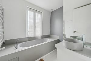 a white bathroom with a tub and a window at KDL - grande maison proche de Paris in Boulogne-Billancourt +26 photos