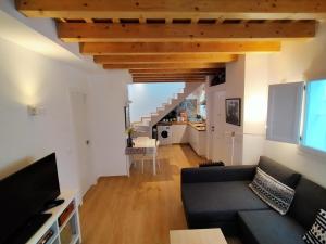 a living room with a couch and a staircase at Casa Santísimo in Vejer de la Frontera