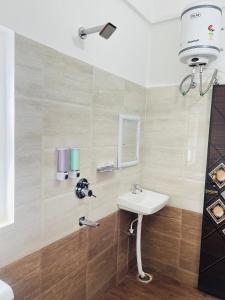 a bathroom with a sink and a mirror at Alpine Inn in Guwahati