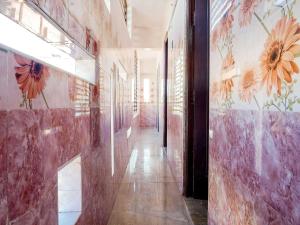 a hallway with flowers painted on the walls of a building at Hotel O KS ELITE in Pasumalai